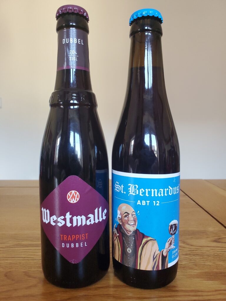 A bottle of Westmalle Trappist Dubbel next to a bottle of St Bernardus Abt 12